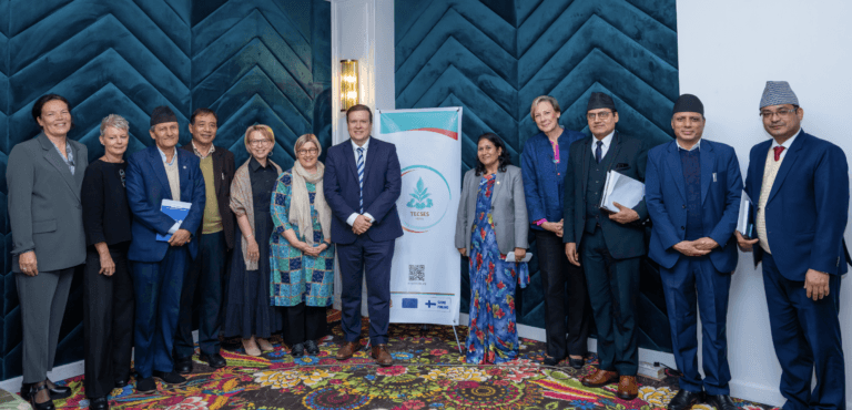High-level officials standing in a row in front the TECSES logo and smiling