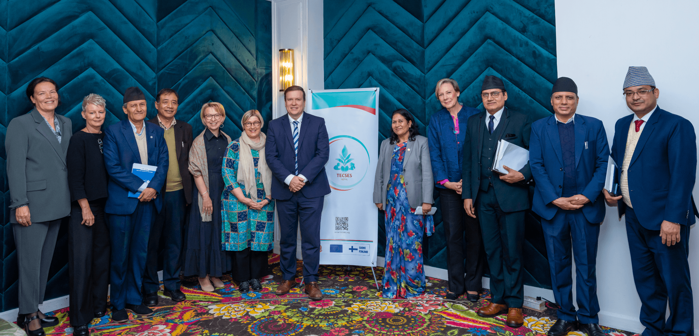 High-level officials standing in a row in front the TECSES logo and smiling