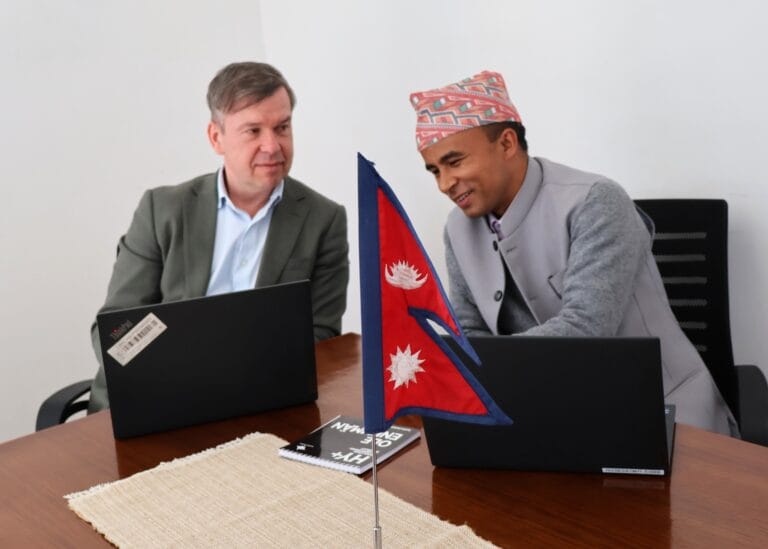 Dr. Marko van den Berg and Krishna Bhujel seated at a table, engaged in discussion.