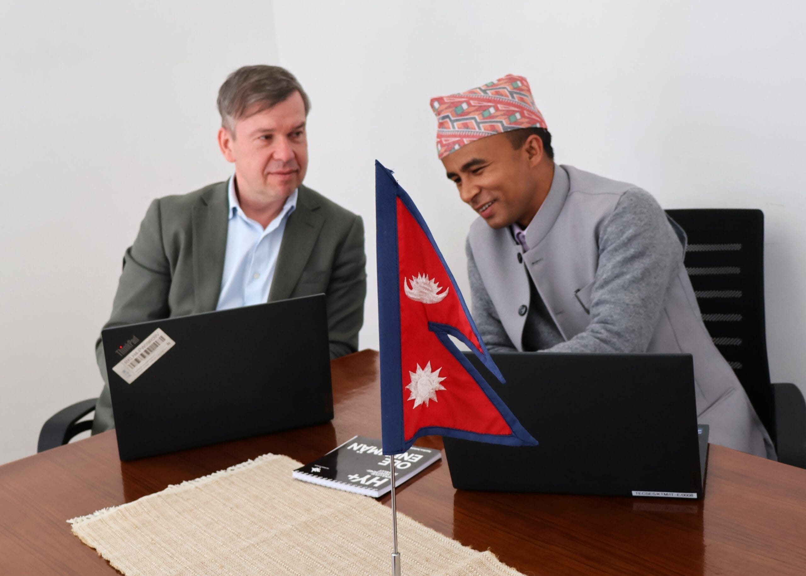 Dr. Marko van den Berg and Krishna Bhujel seated at a table, engaged in discussion.