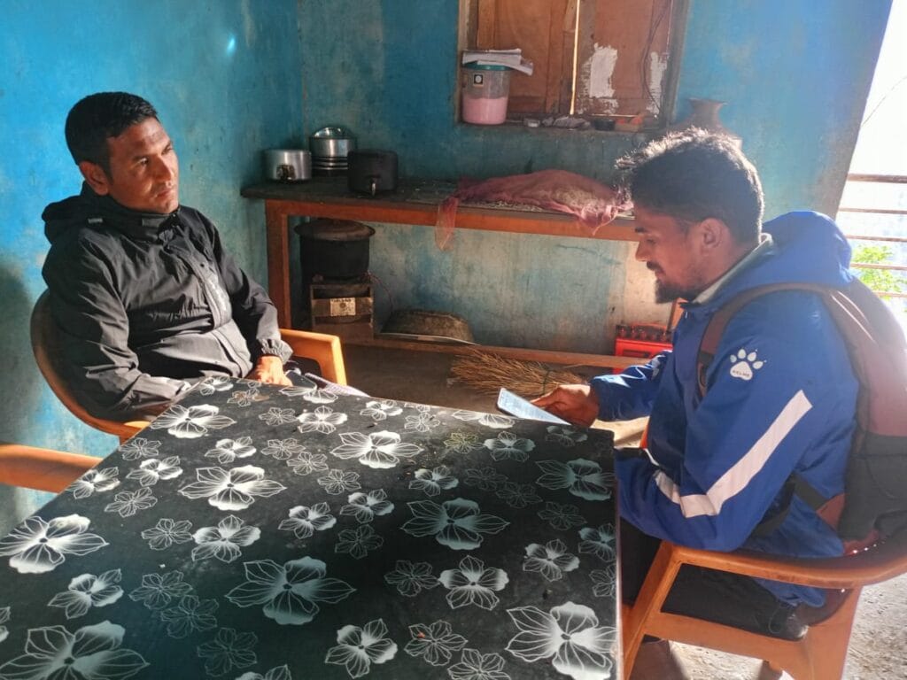 An enumerator asking survey questions from a local teacher in rural Karnali