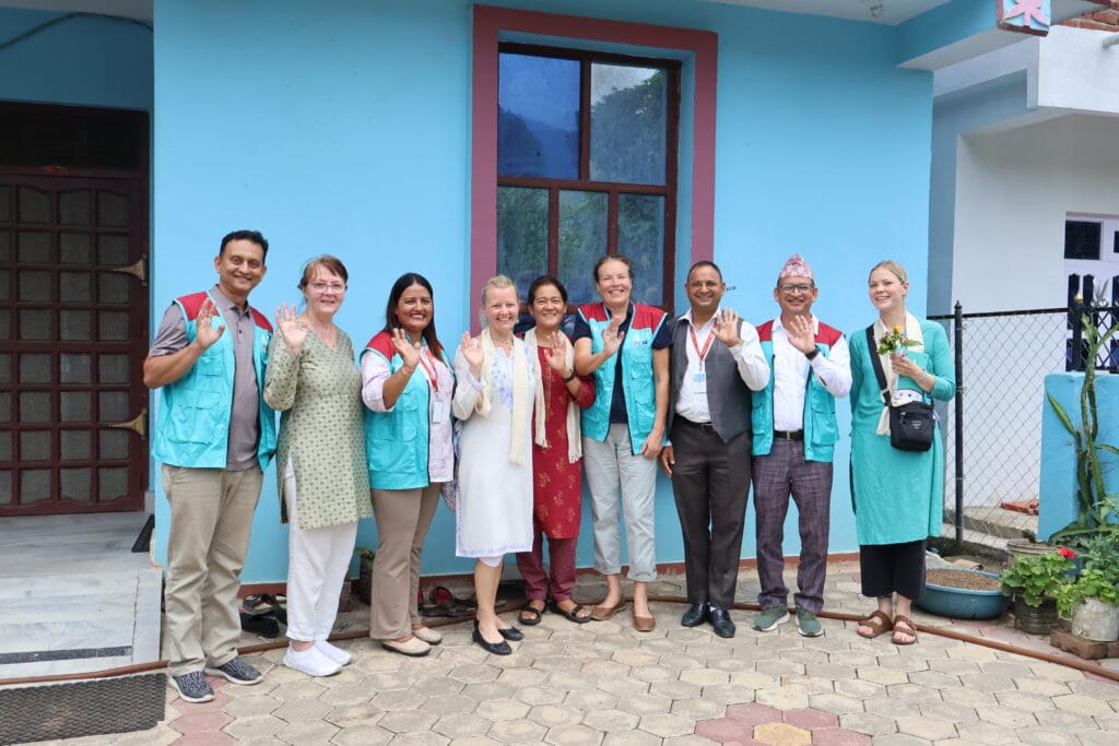 Embassy of Finland and Tecses staff posing for a group picture and waving to the camera
