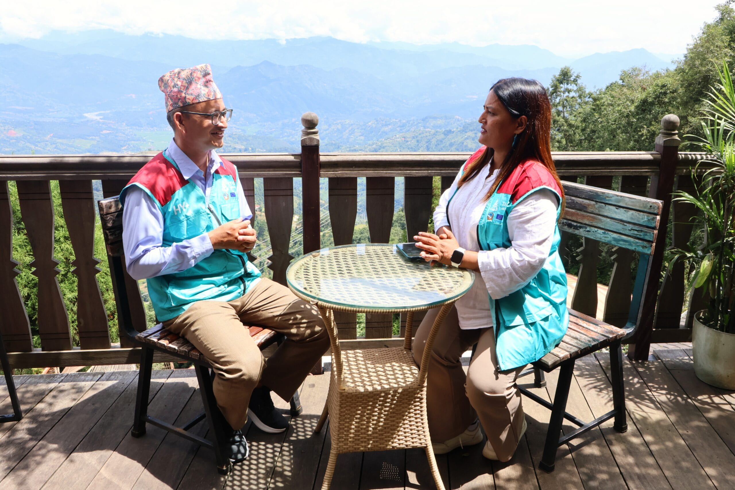 Nawa Raj and Hansa sitting at a table and having a discussion.