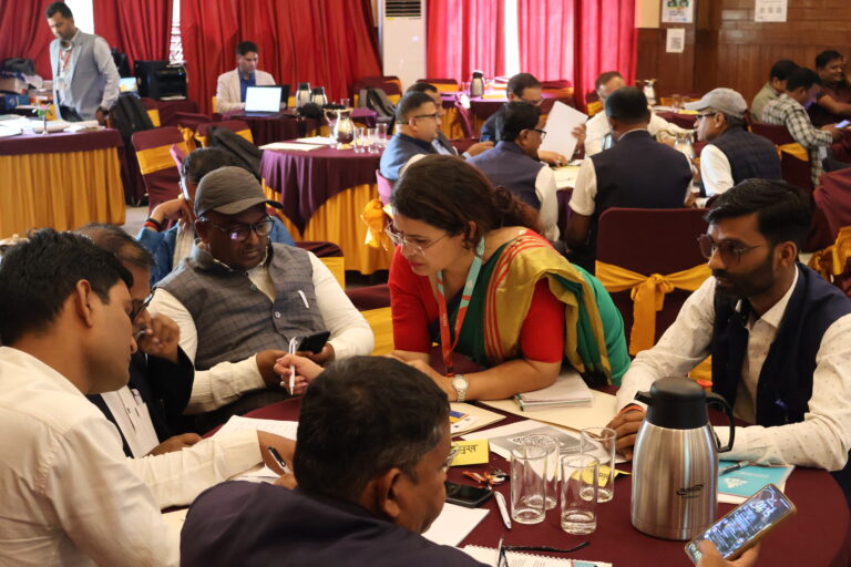 People discussing around a table during the workshop part of the kick-off event in Madhesh